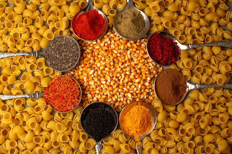 raw-pasta-yellow-along-with-colorful-spices-inside-silver-spoons_179666-702-1